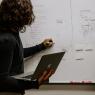 Woman with laptop and whiteboard