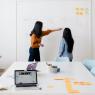 Colleagues putting post-its on a wall