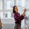 Two women standing in front of whiteboard